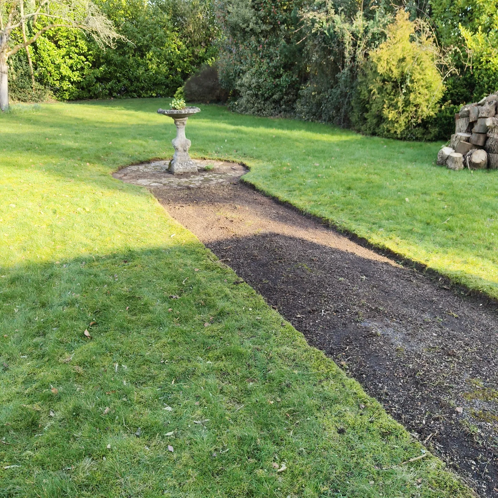 Cleared path with defined lawn edges leading to the bird bath